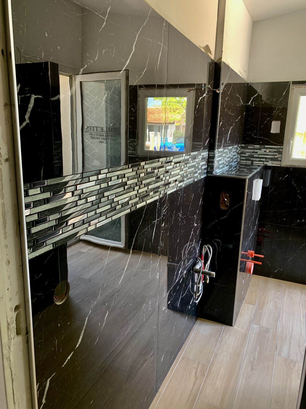 Salle de bain en marbre noir veiné et mosaïque de verre réalisée par AMCarrelage